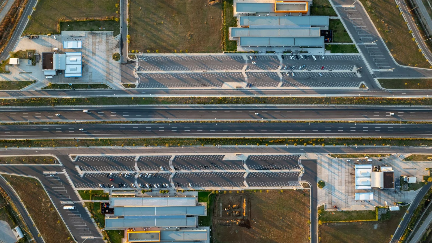 An overhead view of commercial properties, parking areas, and connecting roads.