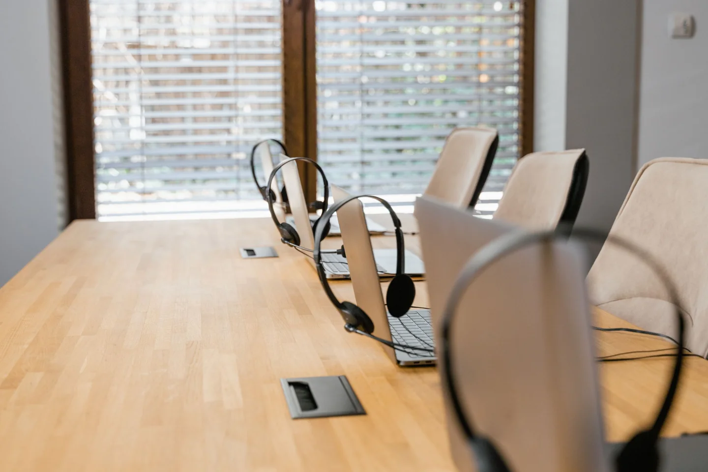A shared customer-service workspace with laptops and headsets ready for a team.